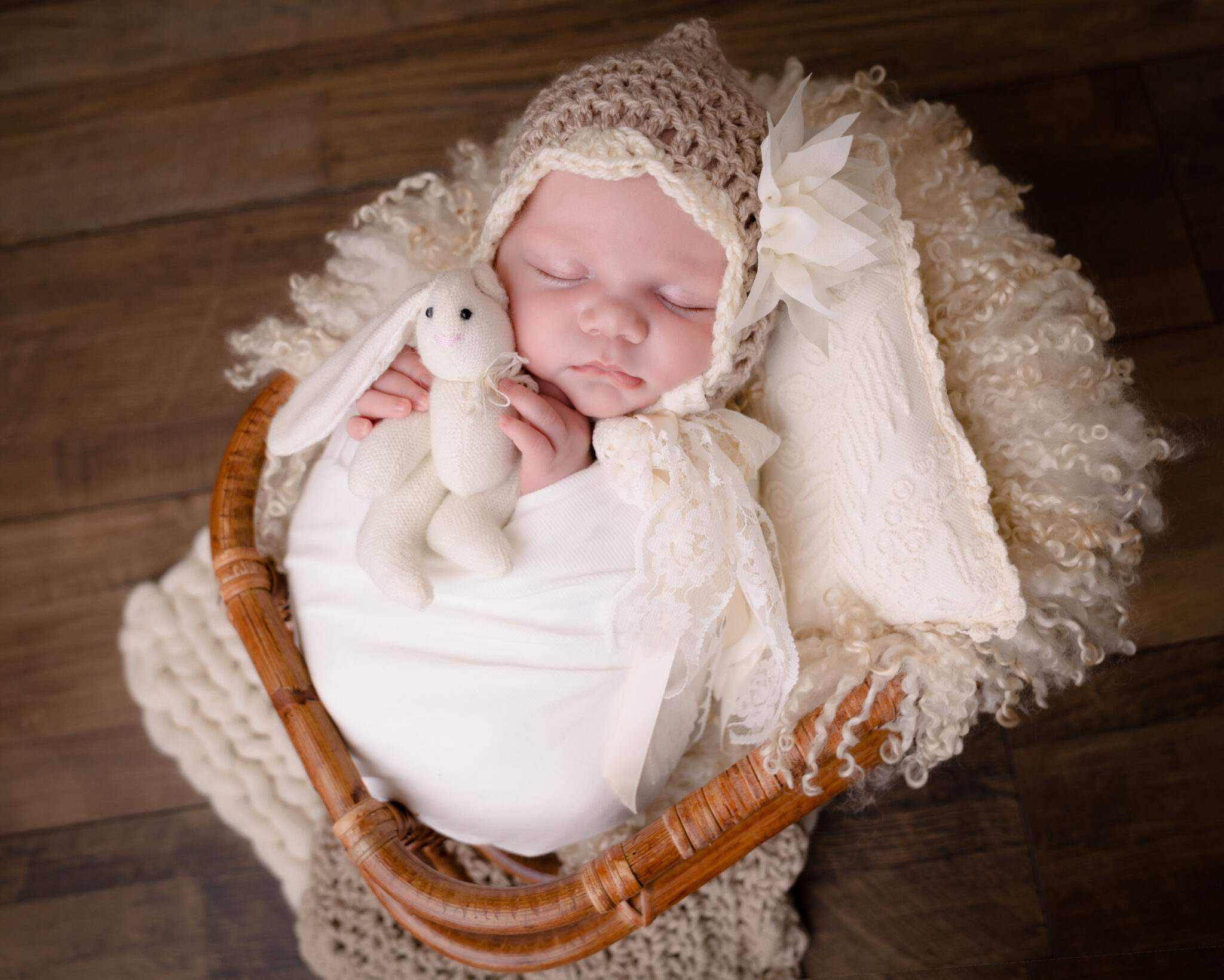 Sleeping baby in basket with toy bunny.