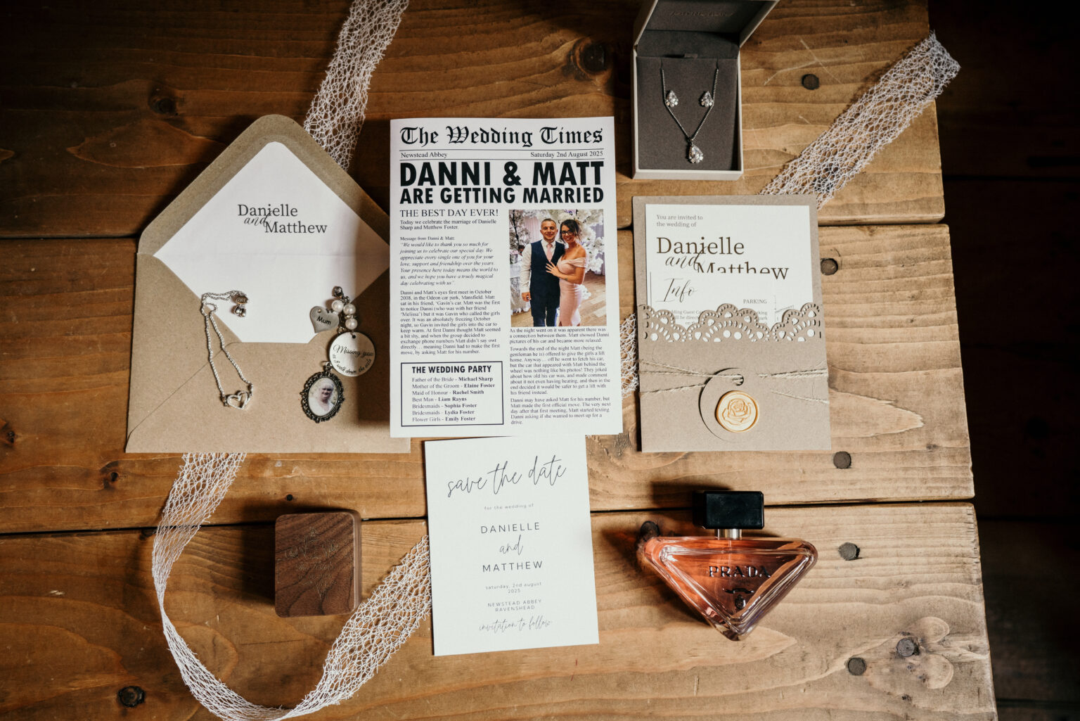 Wedding invitations and jewellery on wooden table.