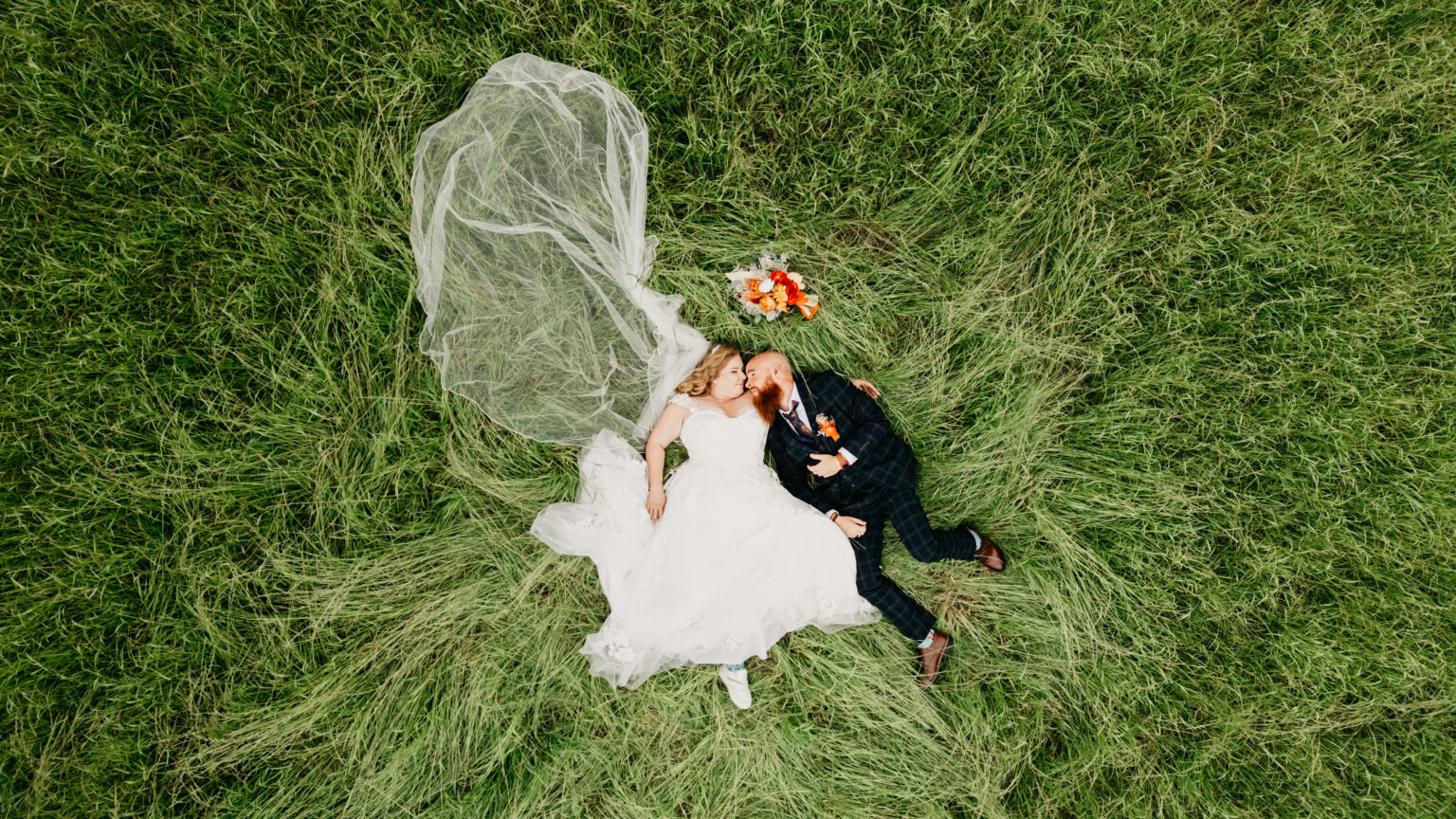 Bride and groom lying on grass