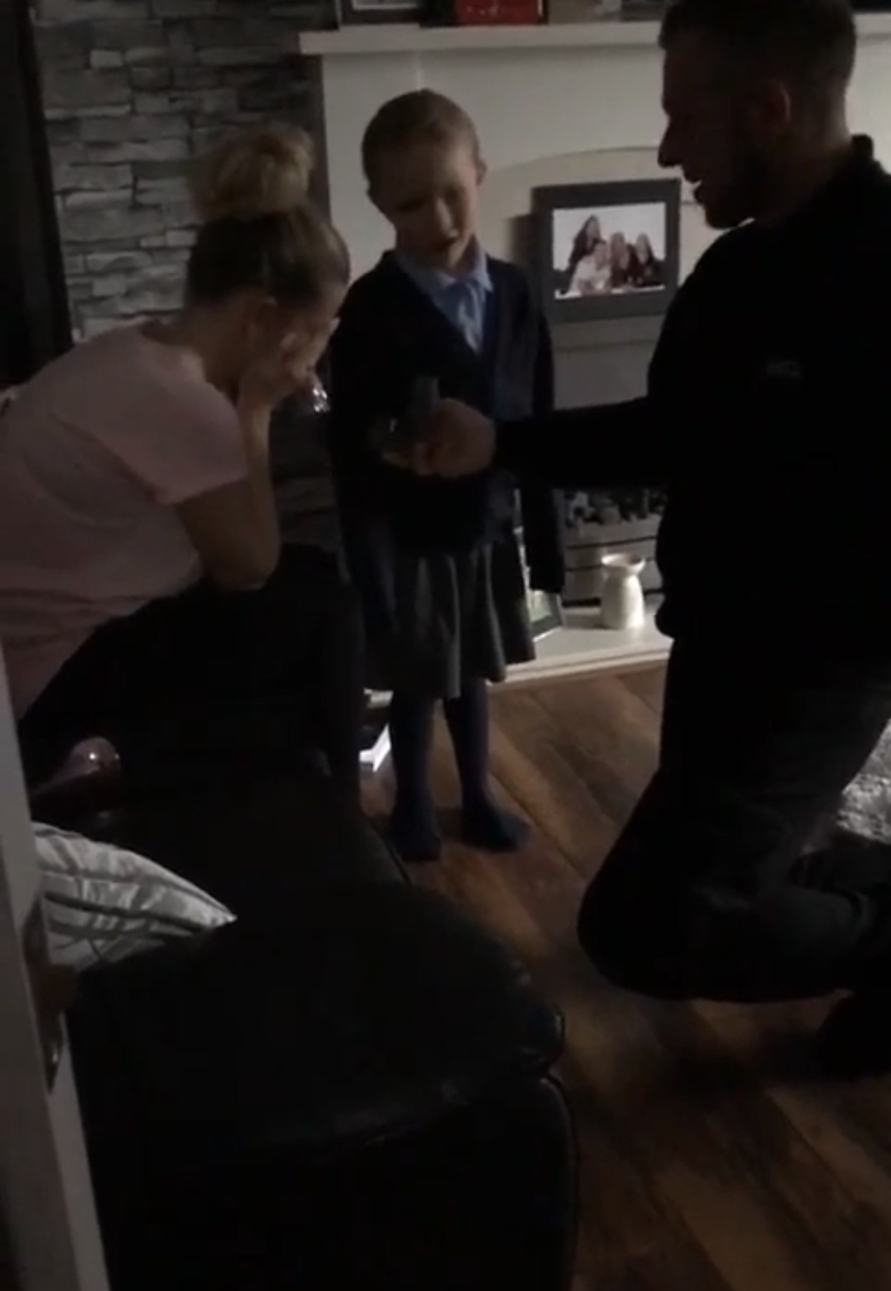 Man proposing to woman and child watching.