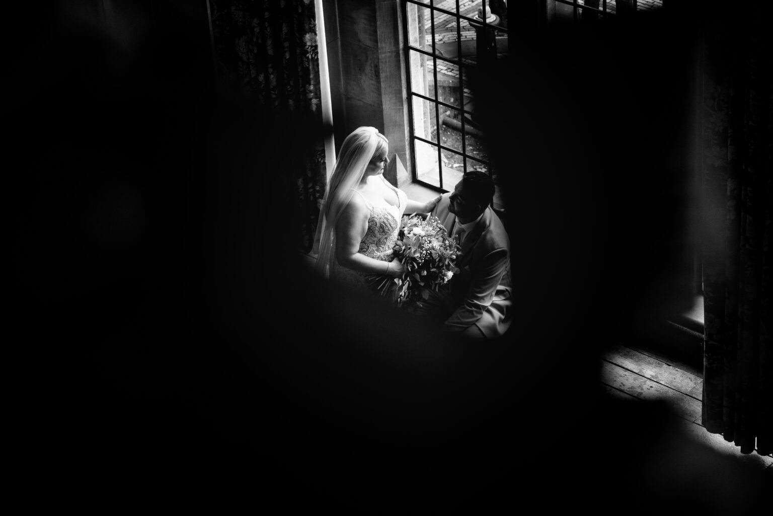 Bride and groom by window in silhouette