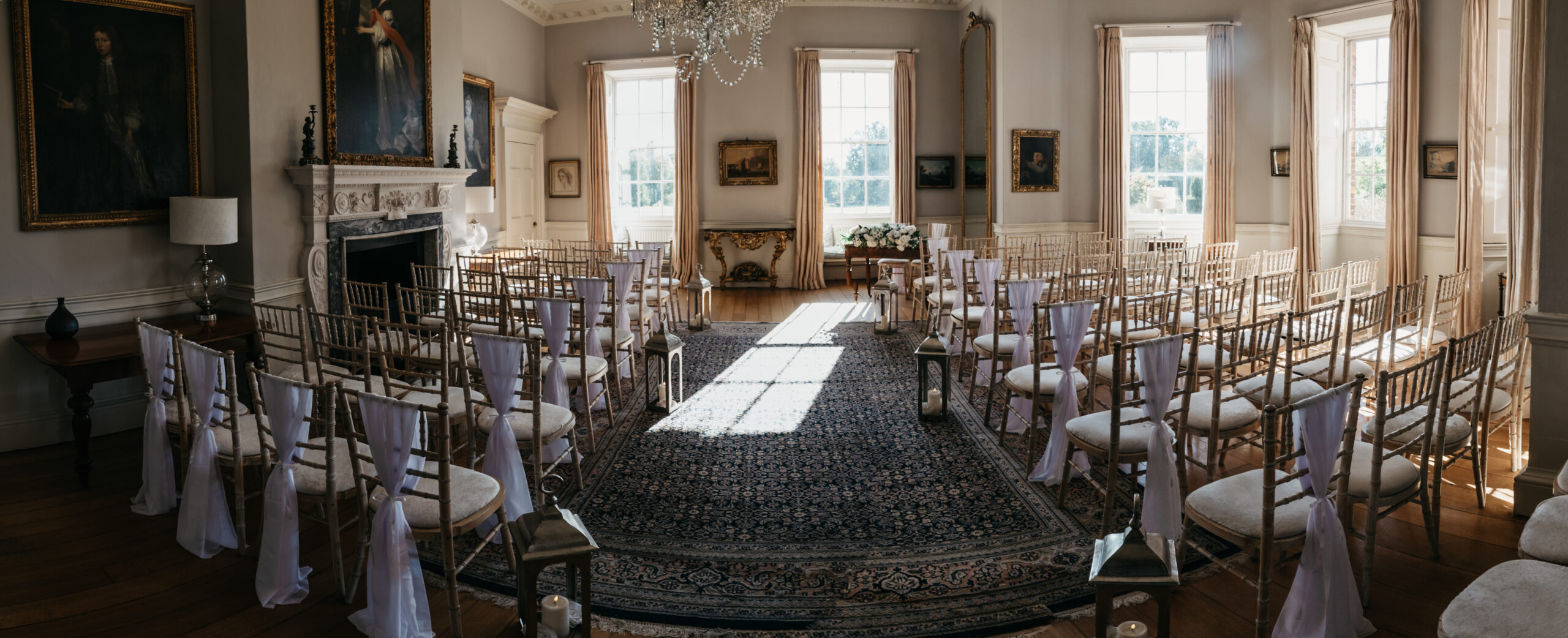 Sunlit room with elegant chairs and paintings.