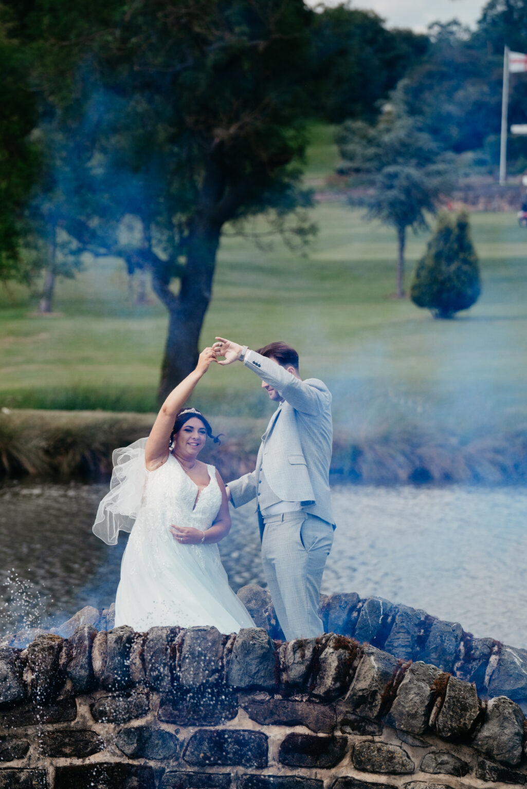 Bride and groom dancing on a stone bridge