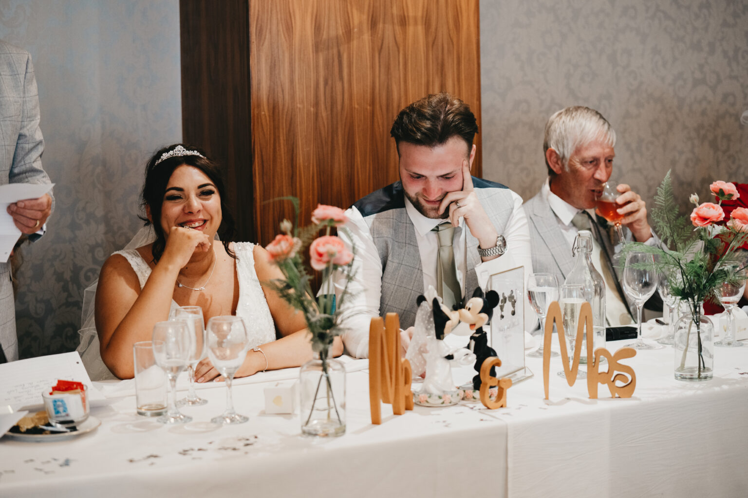 Bride and groom smiling at wedding reception.