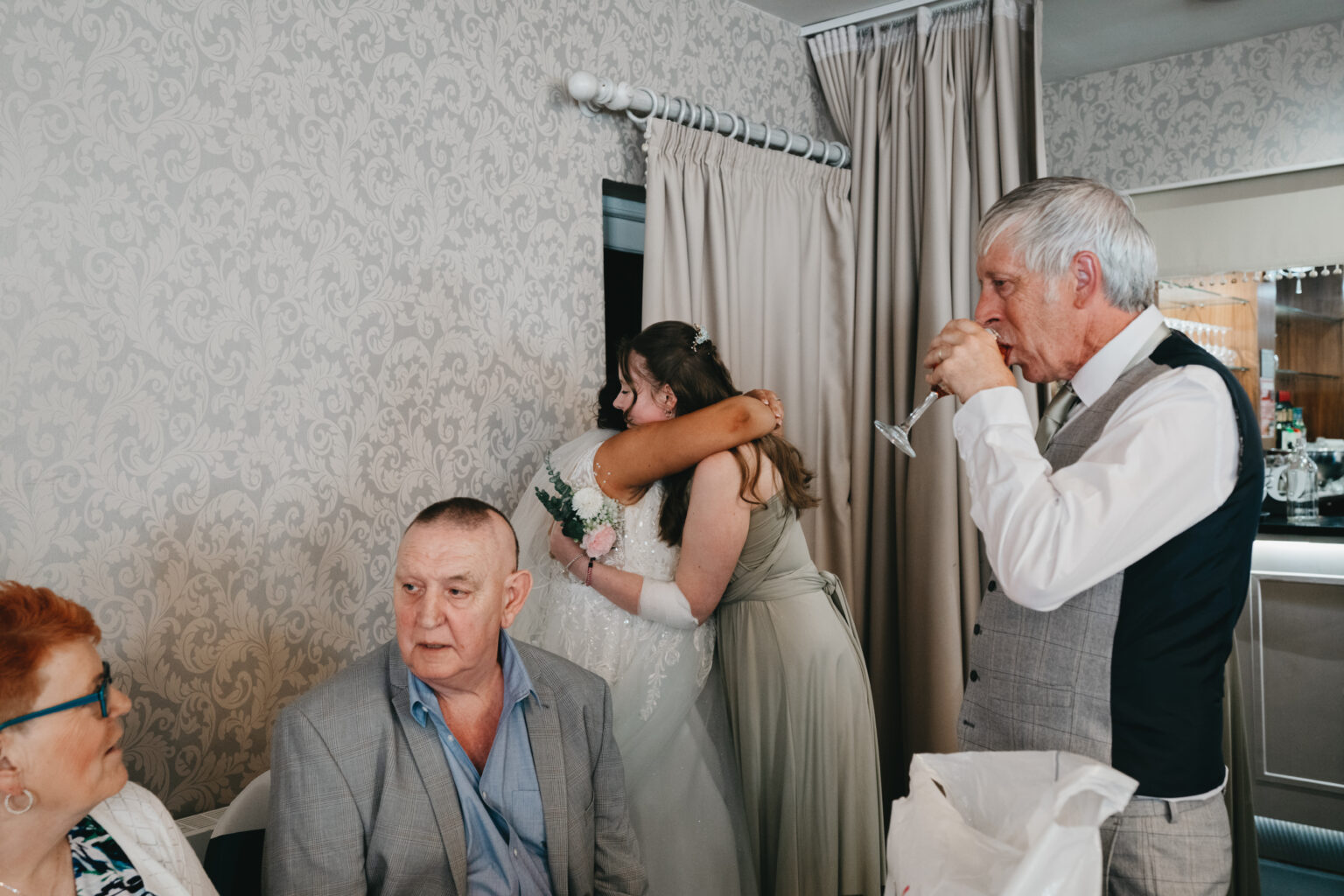 Wedding guests embrace and enjoy a celebration.