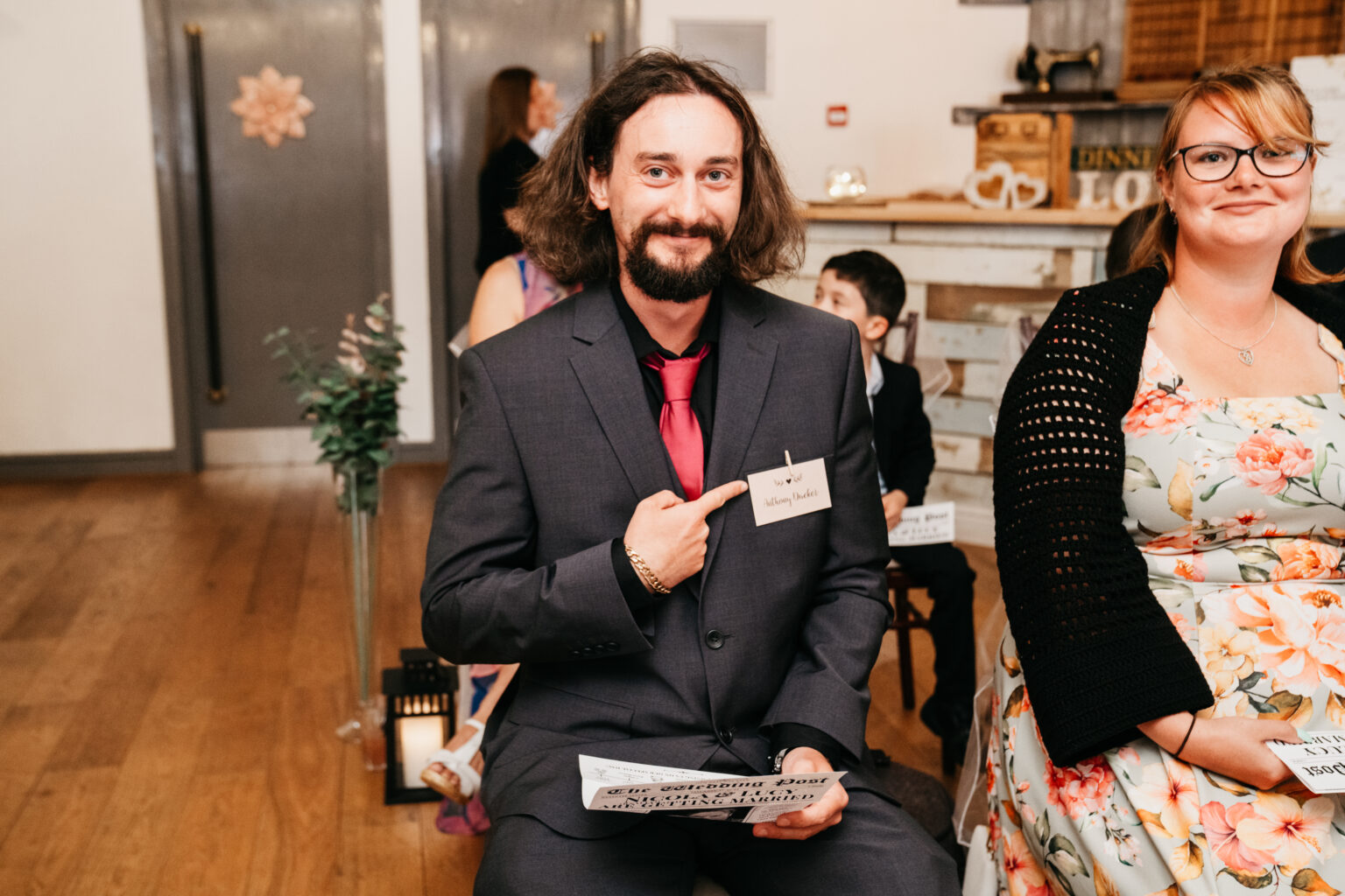 Man in suit pointing at name tag