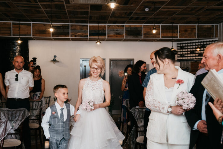 Bride and page boy enter wedding ceremony.