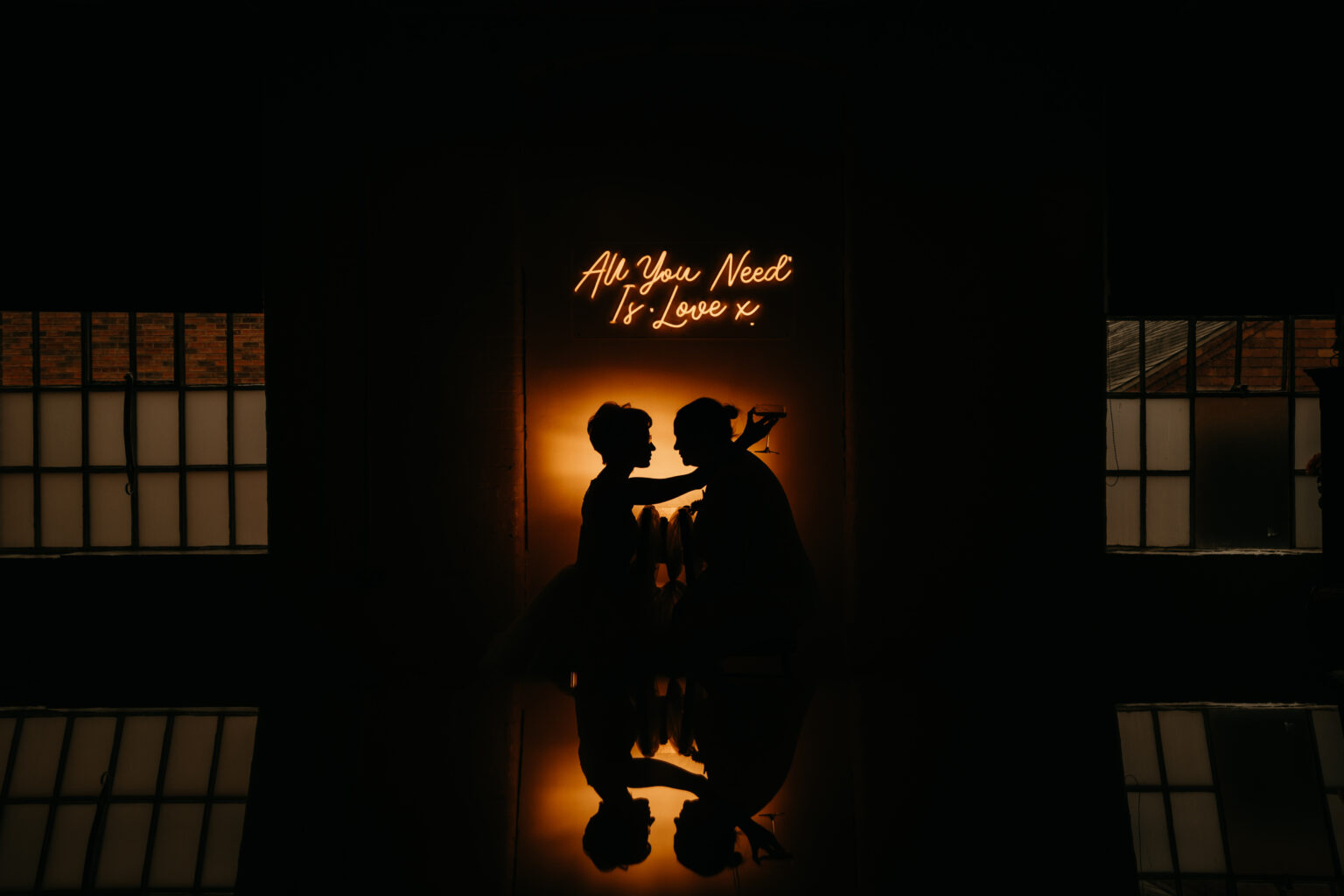 Silhouetted couple embracing in romantic dim light.