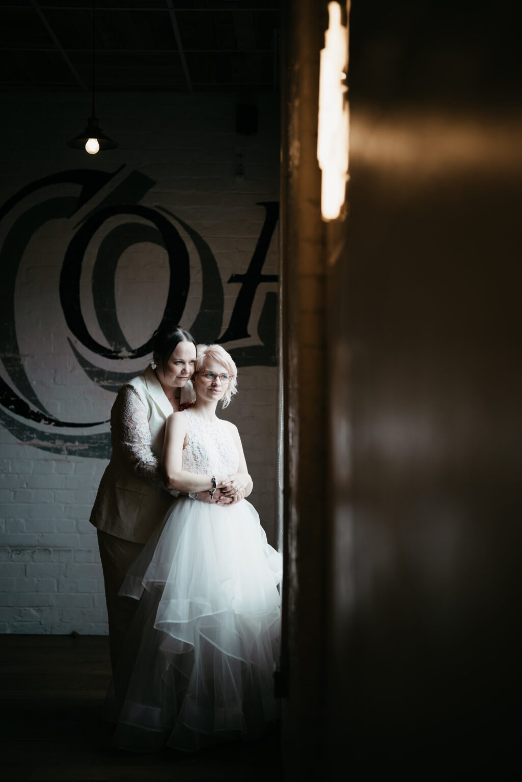 Couple embracing in elegant wedding attire.