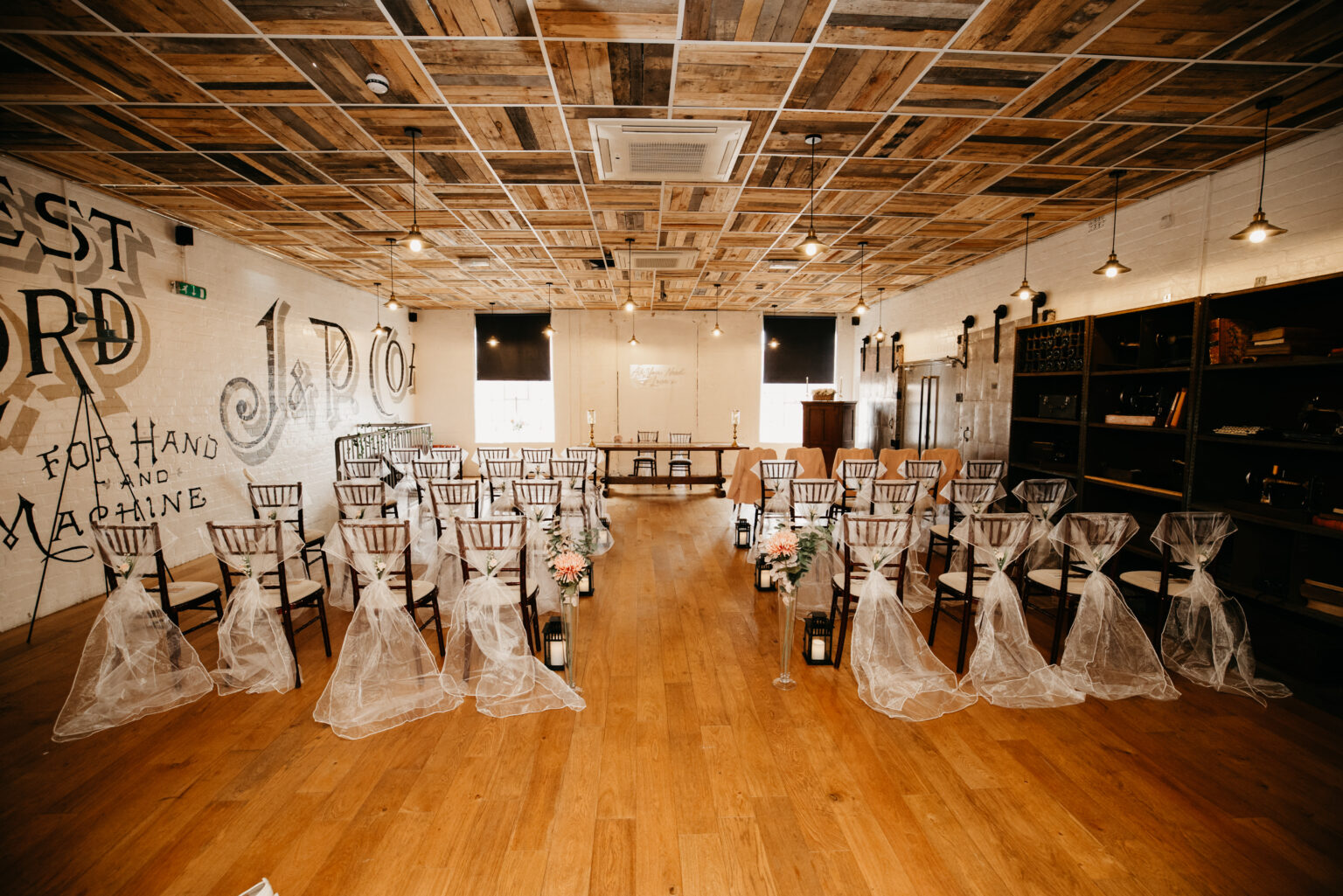 Rustic wedding ceremony venue with decorated chairs.