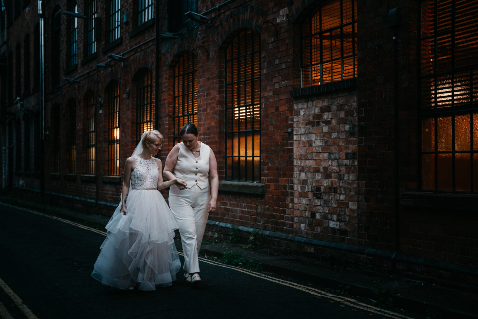 Two women walking together, one in wedding dress.
