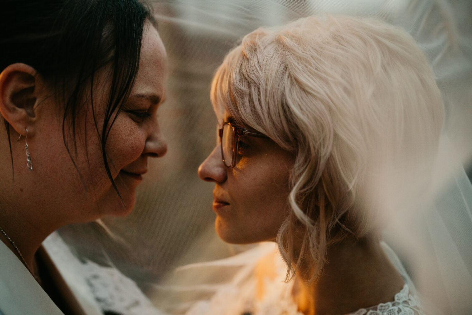 Two women facing each other, close-up portrait.