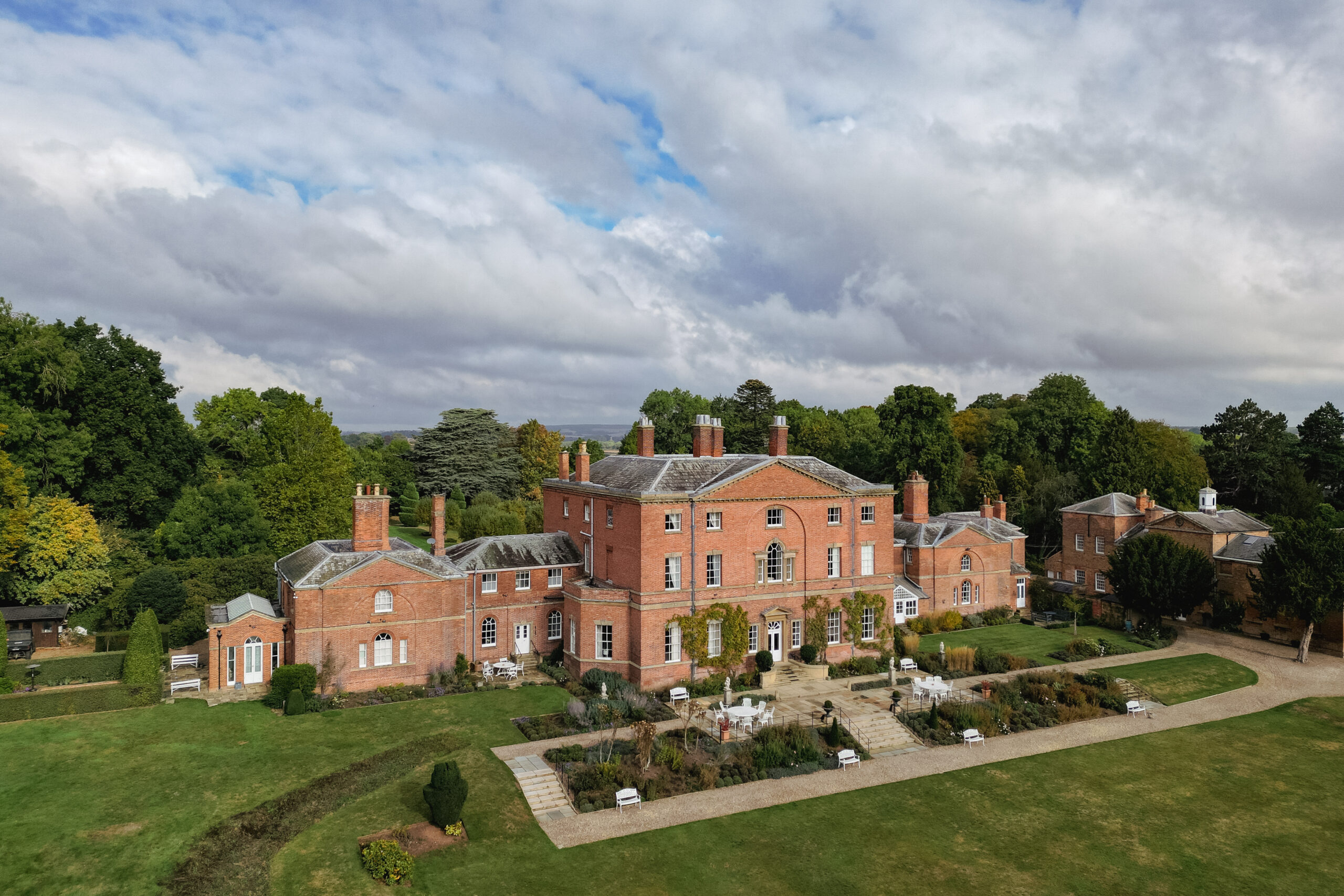 Aerial view of a large, historic red-brick mansion.