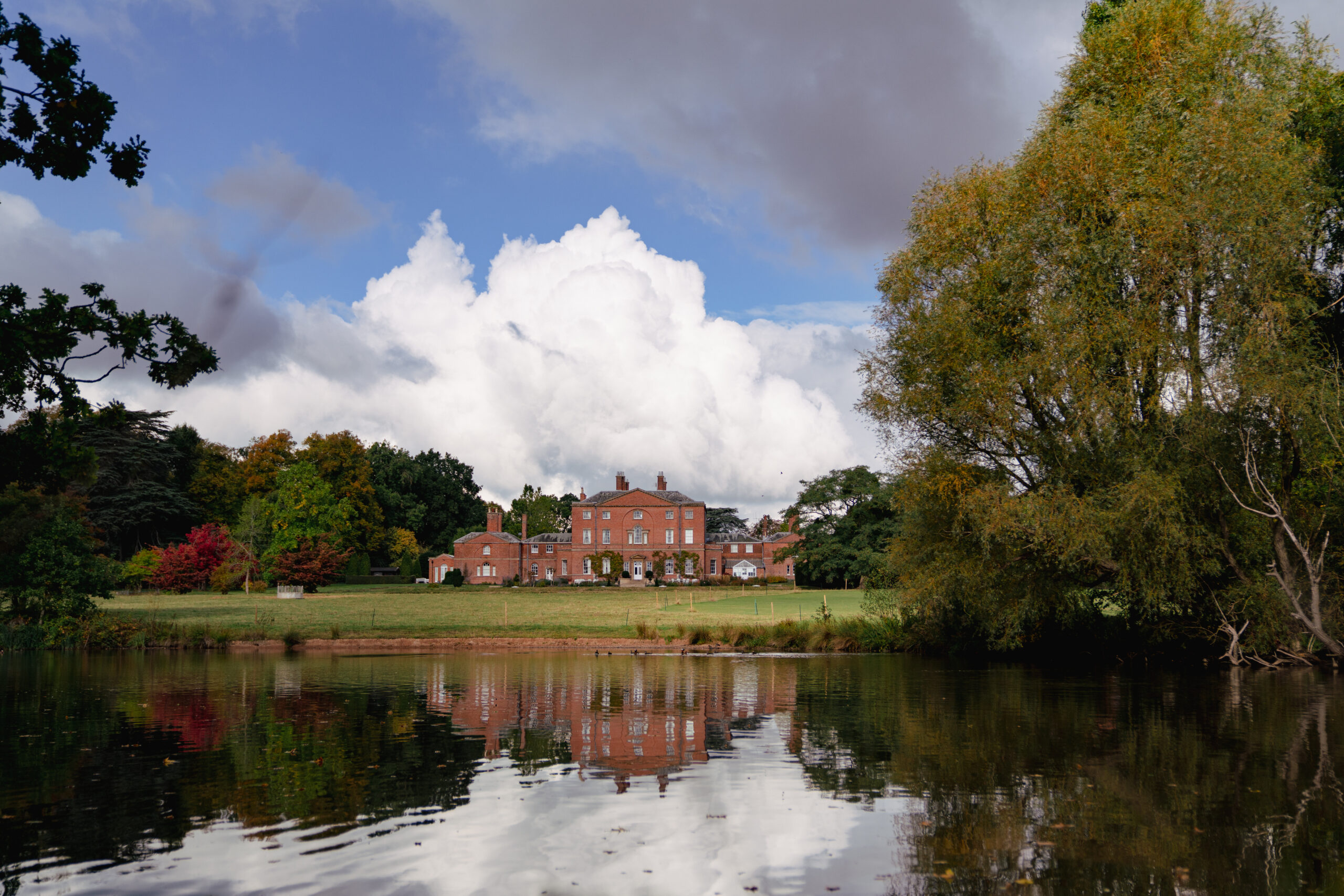 Historic estate with gardens by a reflective lake