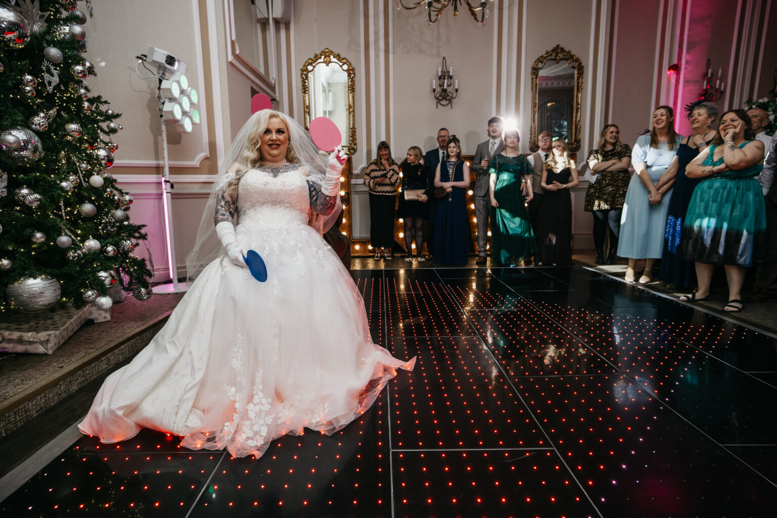 Bride playing table tennis at wedding reception.
