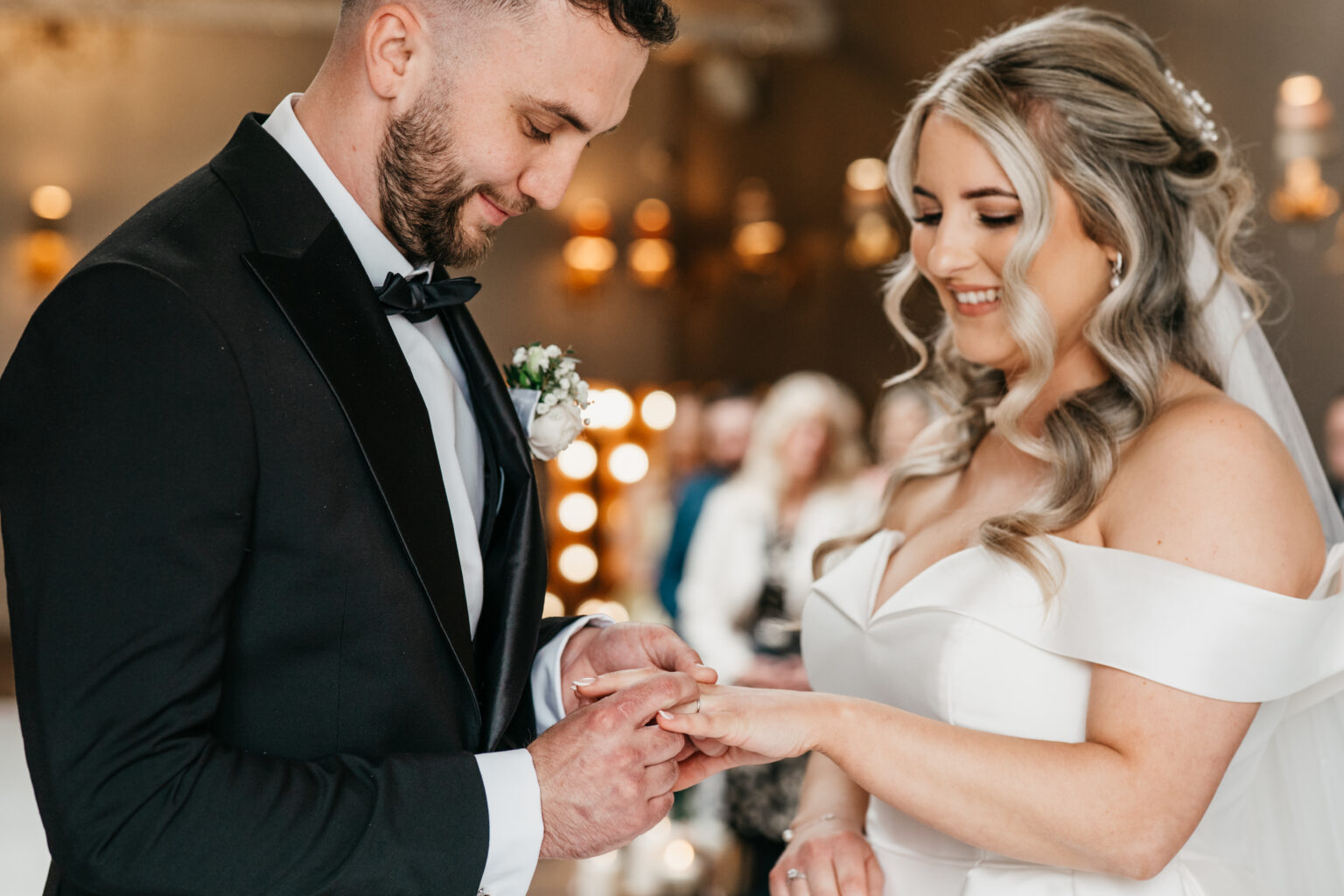 Bride and groom exchange wedding rings.