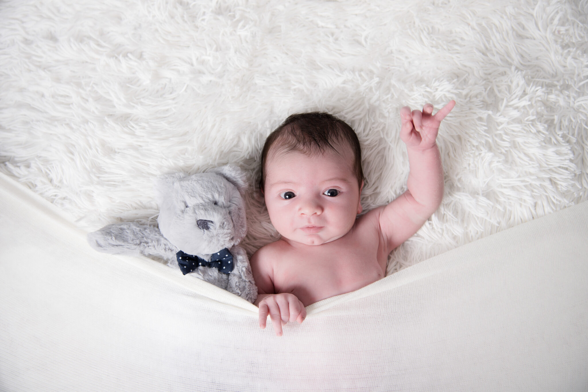 Baby with teddy bear on fluffy blanket