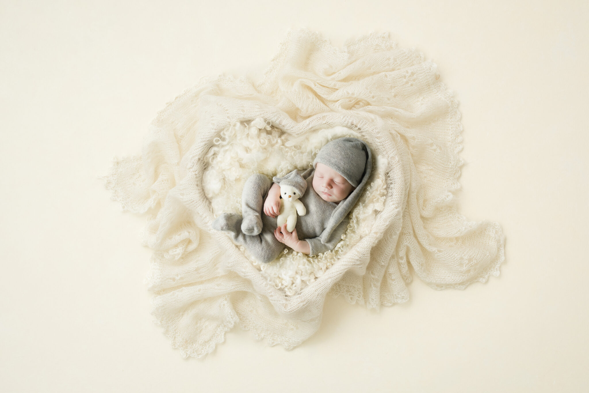 Sleeping baby wrapped in soft cream blanket