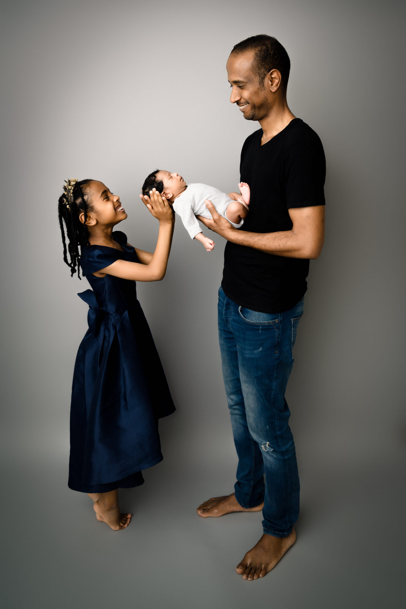 Man and girl holding newborn baby