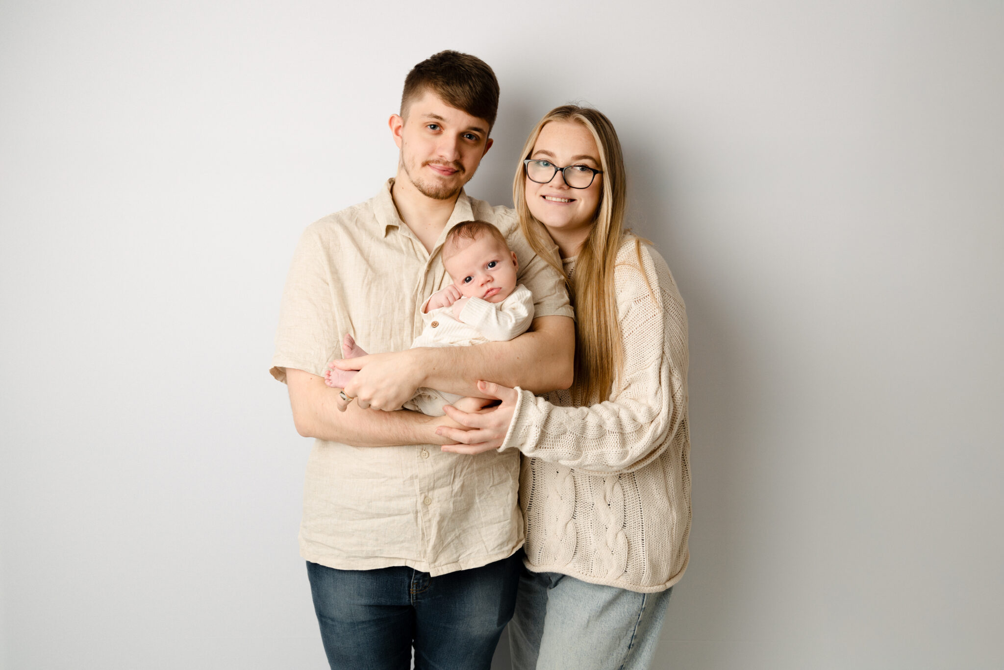 Family with baby smiling against white background