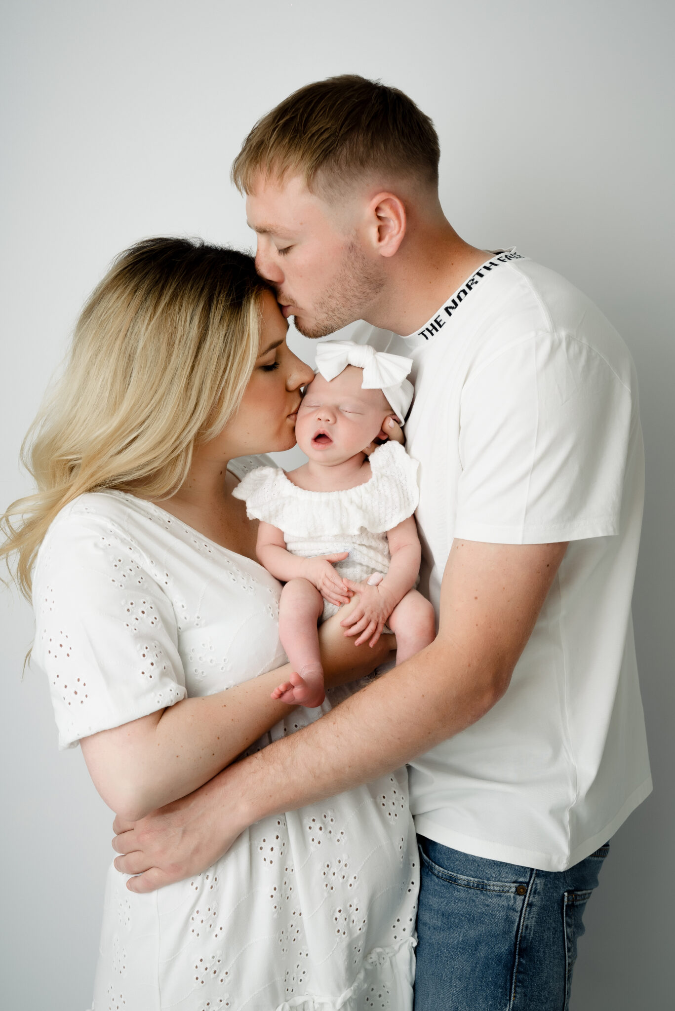 Parents cuddling newborn baby lovingly