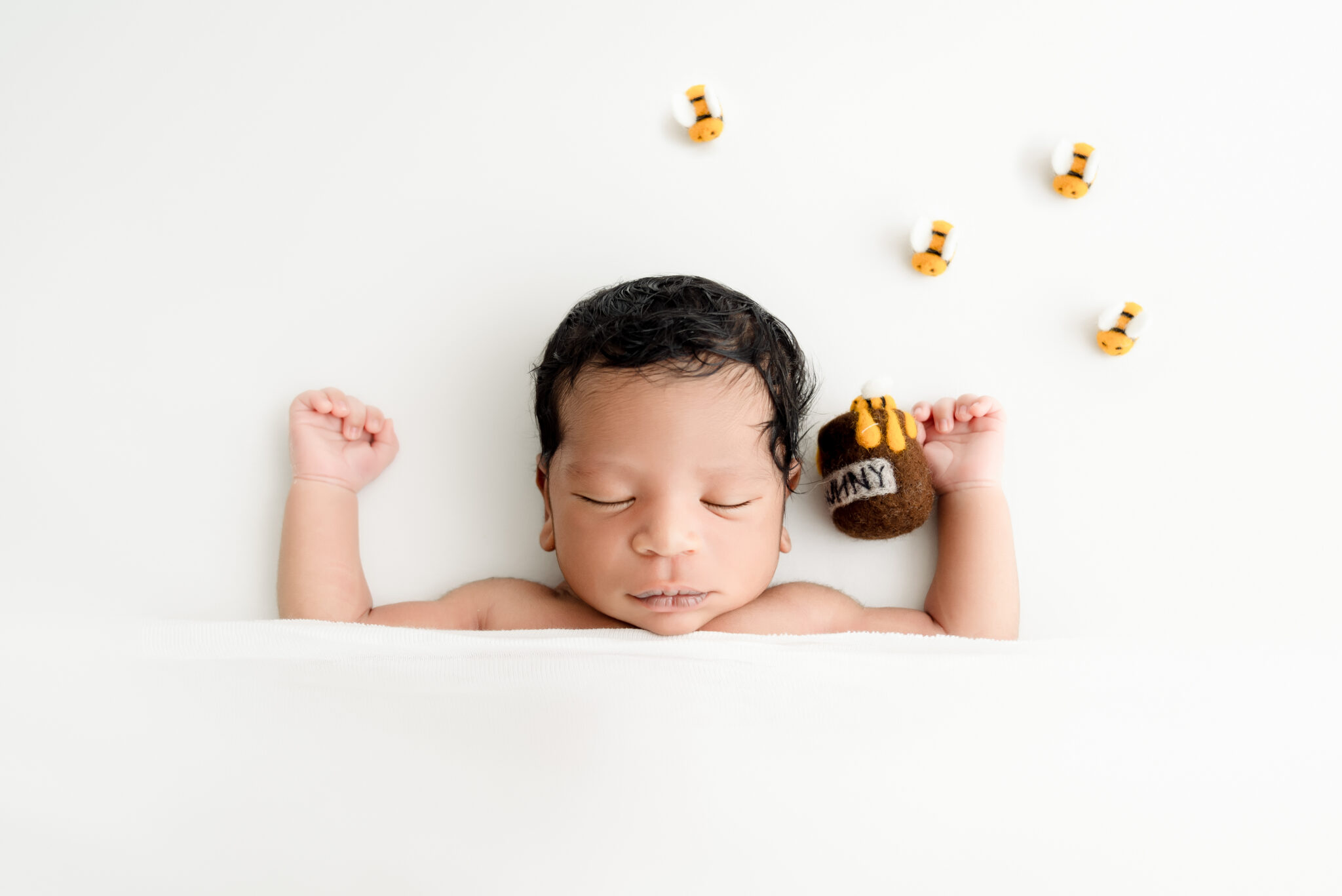 Newborn baby sleeping with bee decorations.