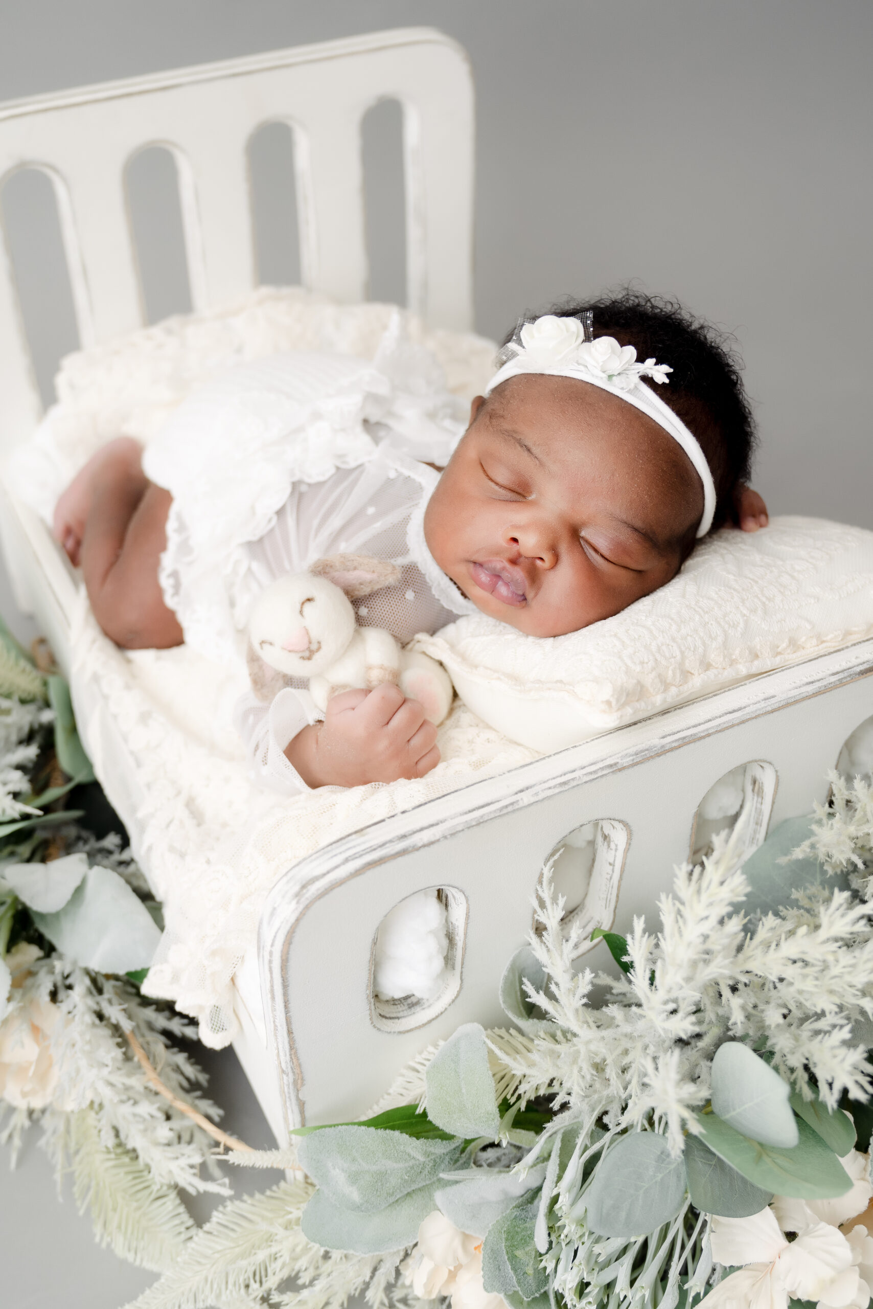 Baby sleeping in a cot with stuffed toy