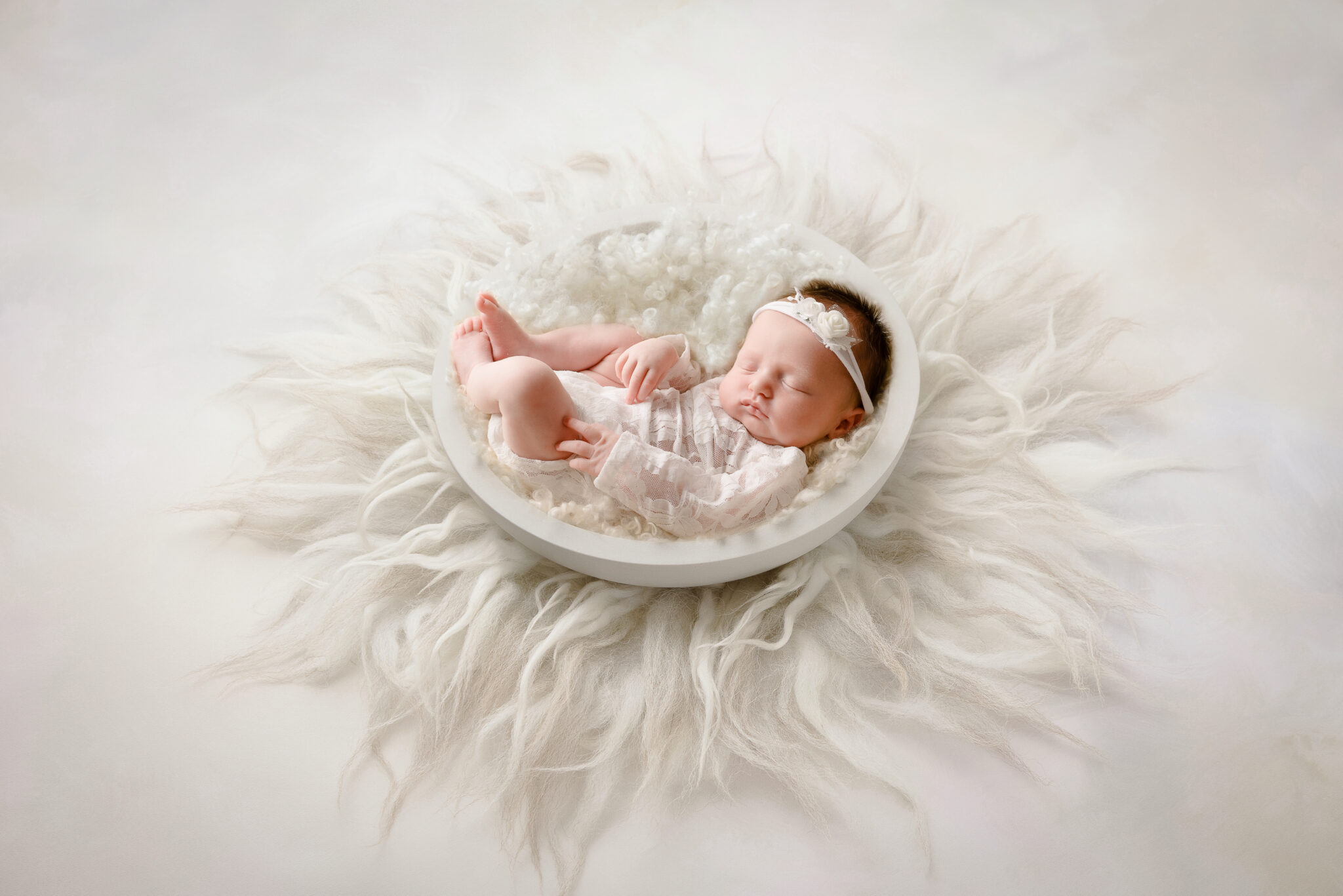 Sleeping baby in fluffy white nest