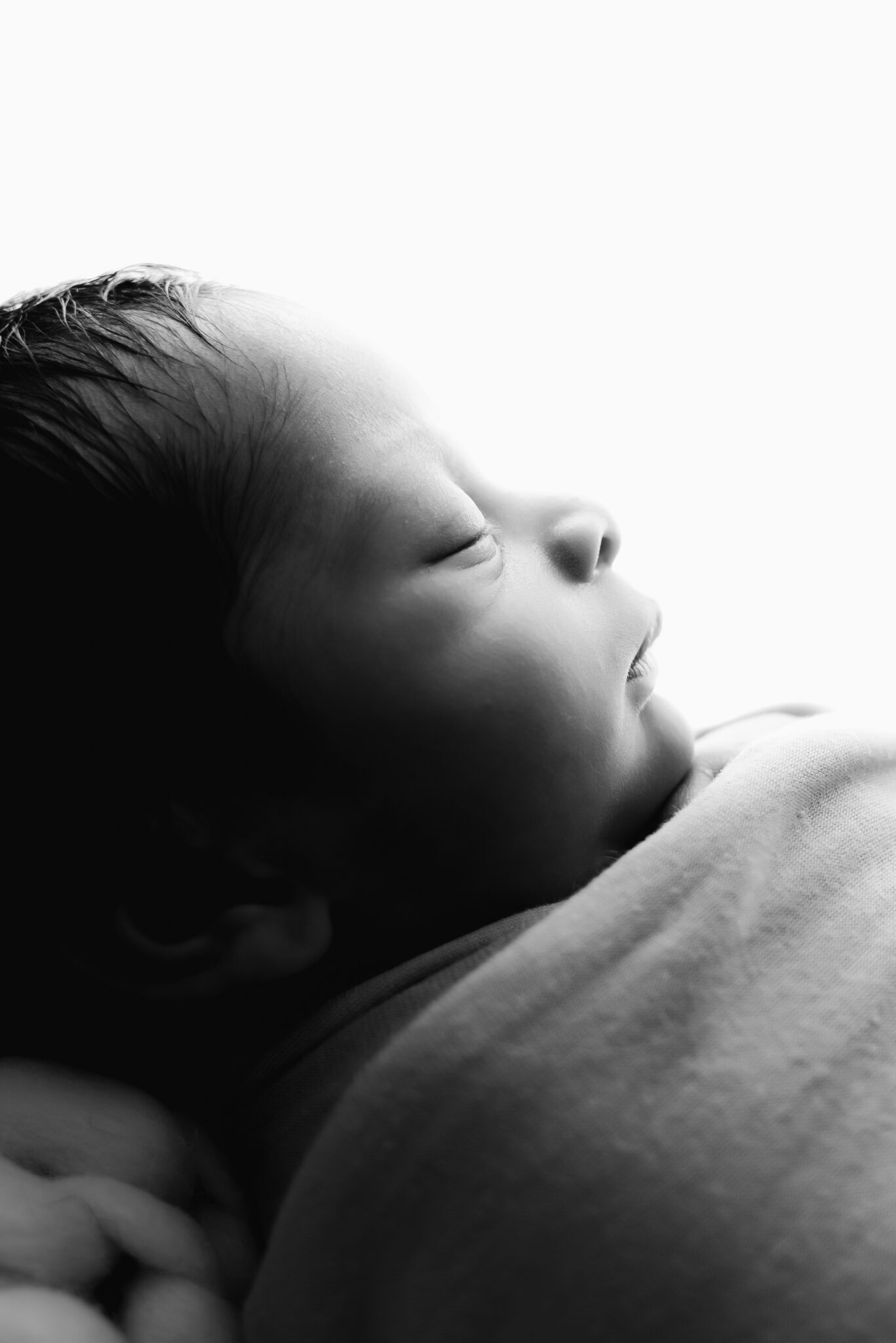 Close-up of sleeping newborn baby in black and white.