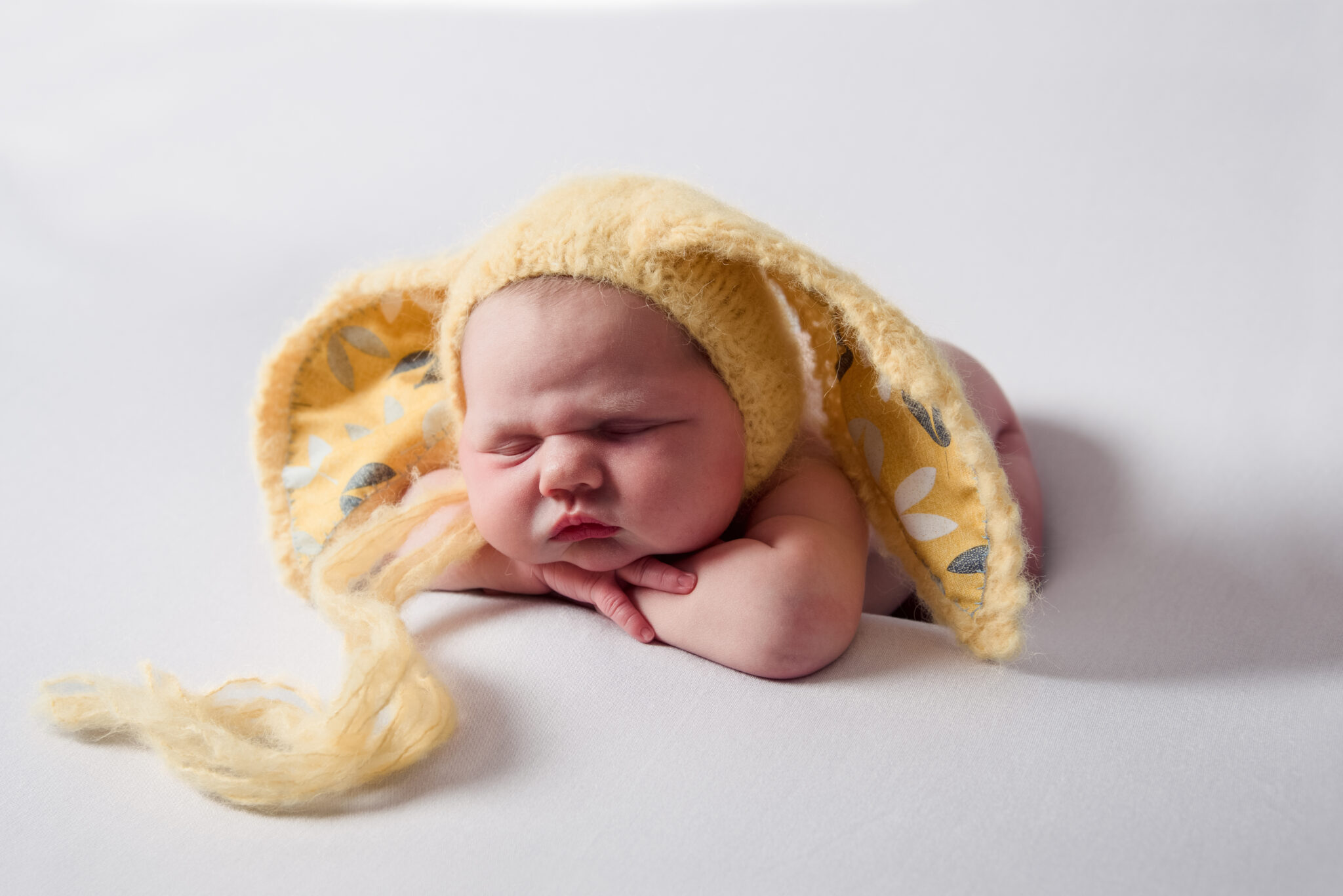 Newborn baby wearing fluffy yellow bunny hat