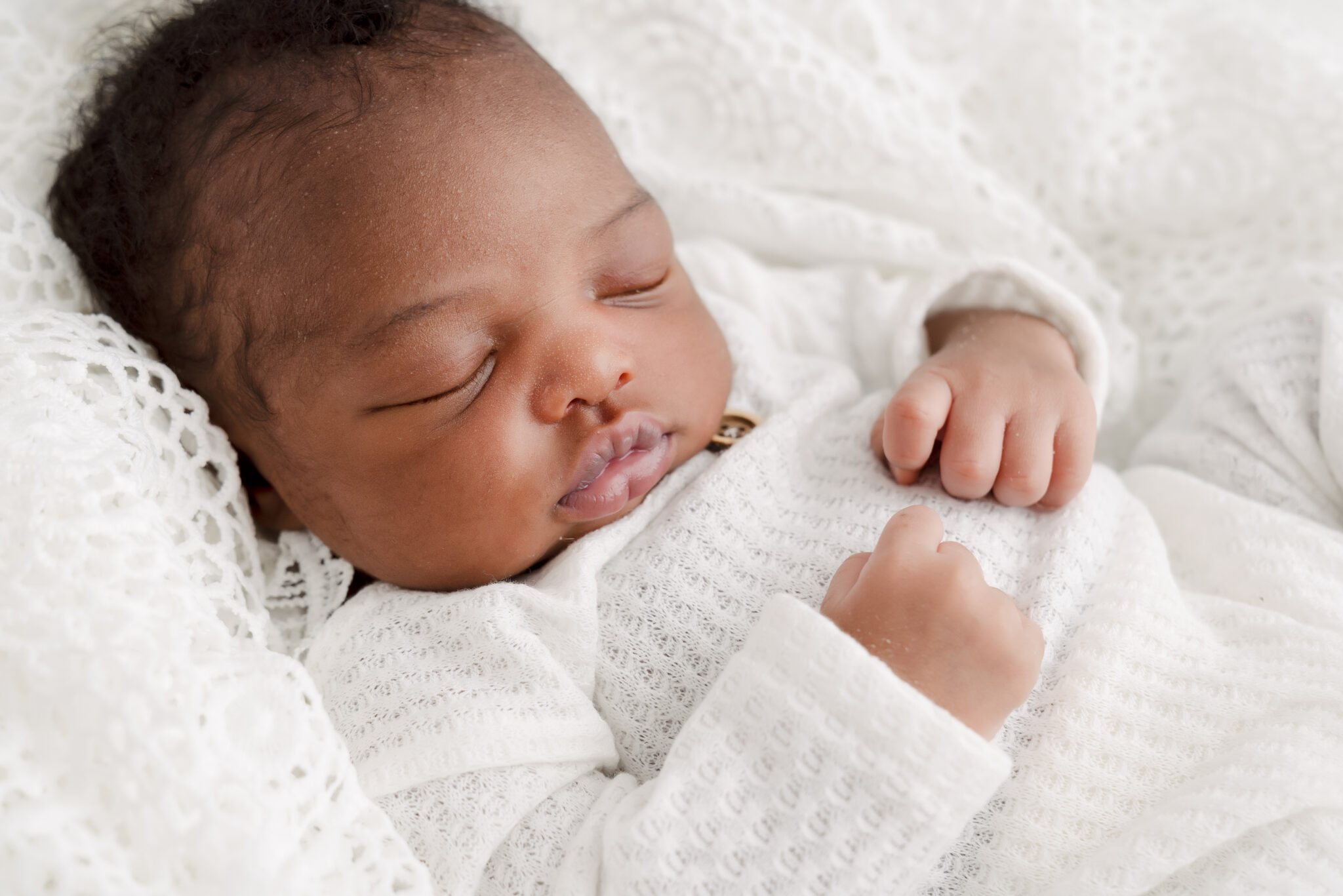 Sleeping baby in white blanket, peaceful and cosy.