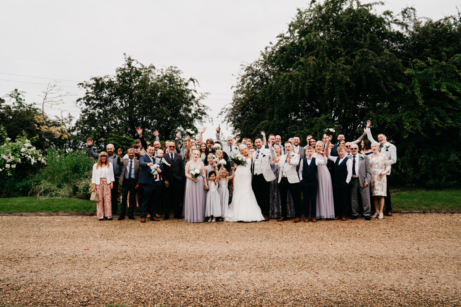 Large wedding group celebrating outdoors