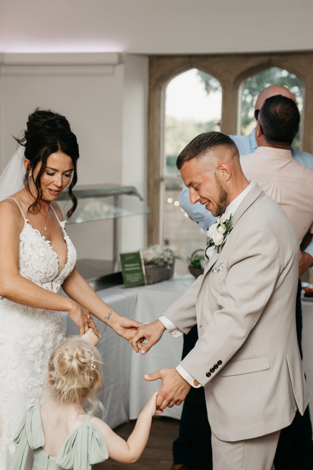 Couple dancing with young girl at wedding