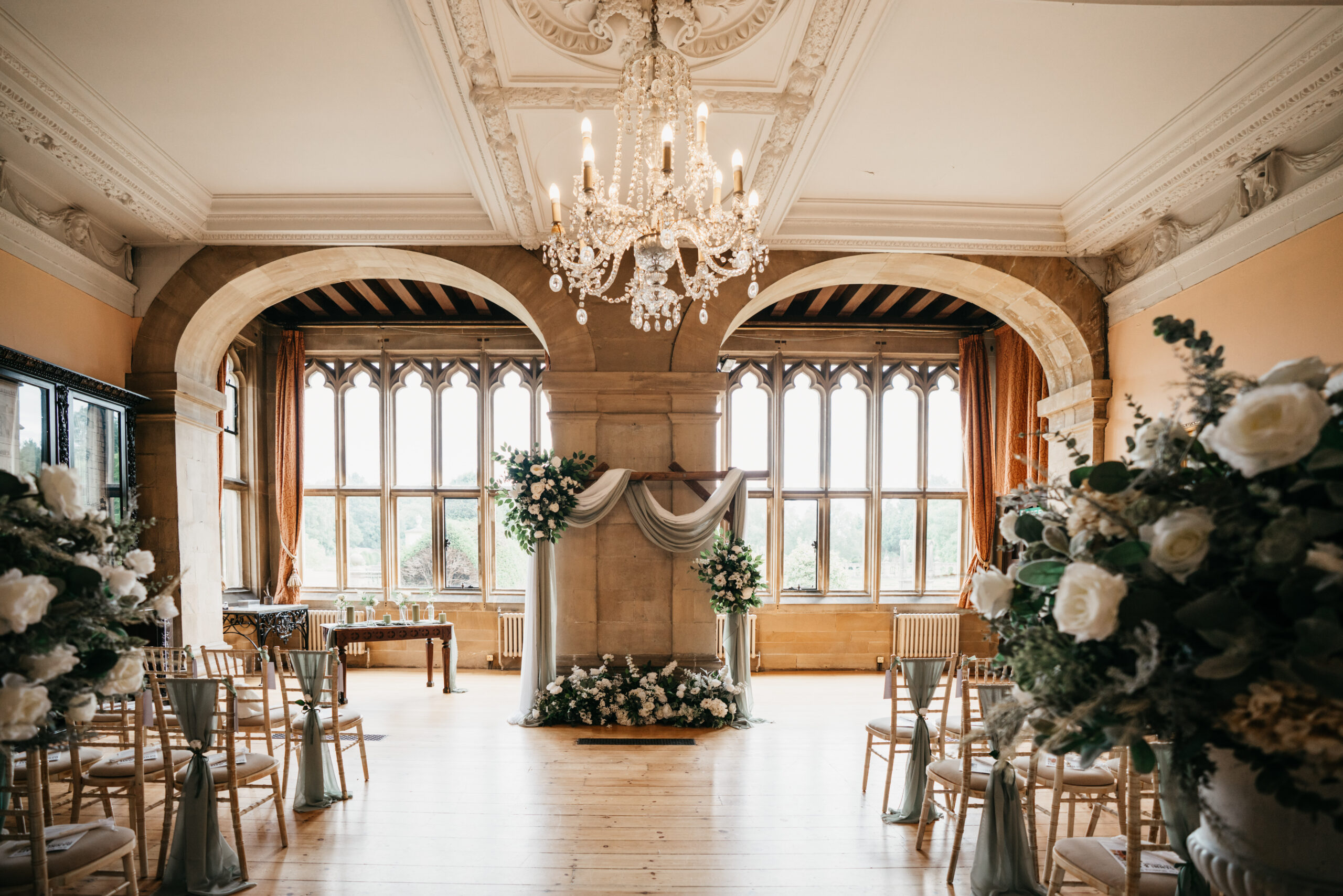 Elegant wedding venue with floral decorations and chandelier.