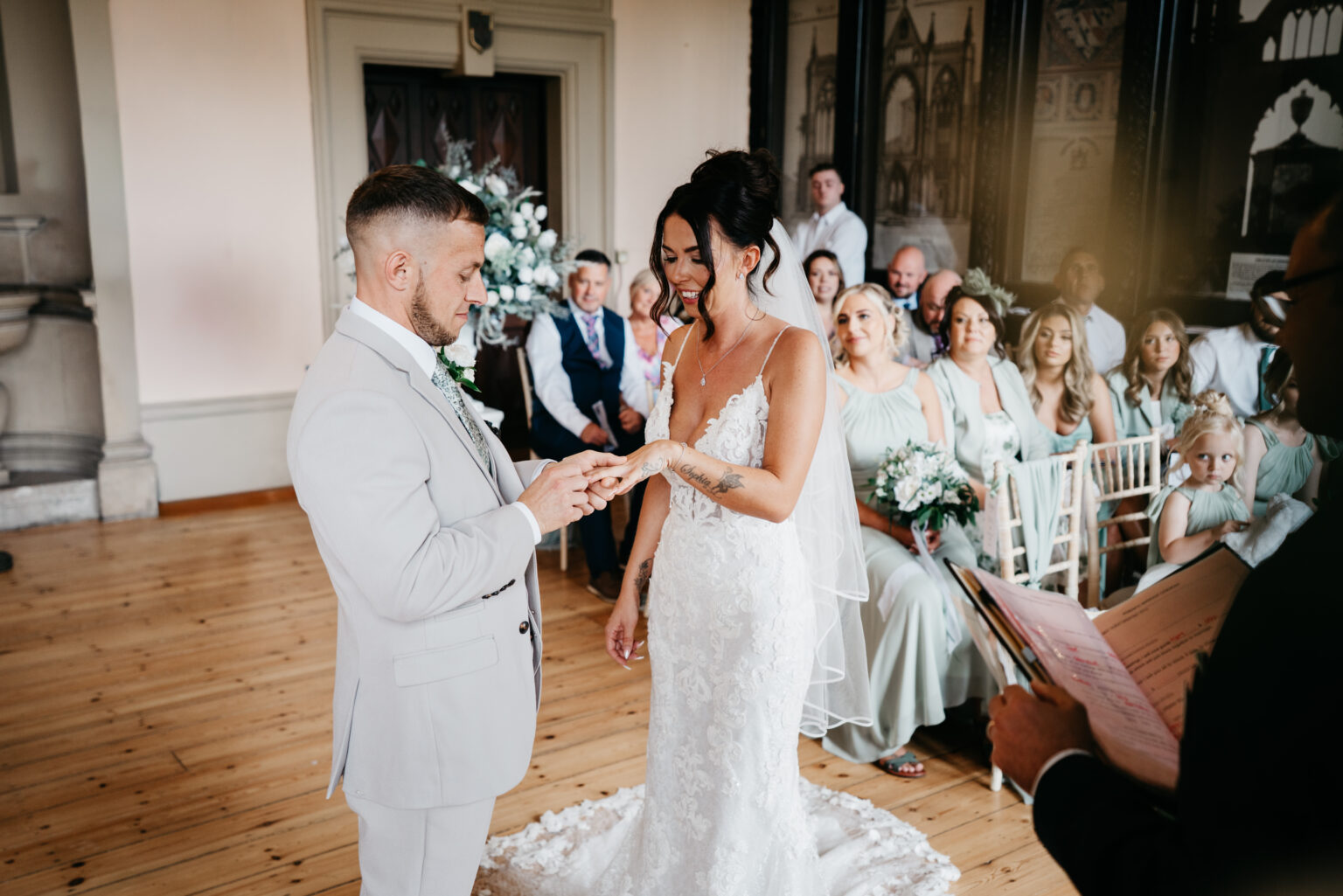 Bride and groom exchange rings during wedding ceremony.