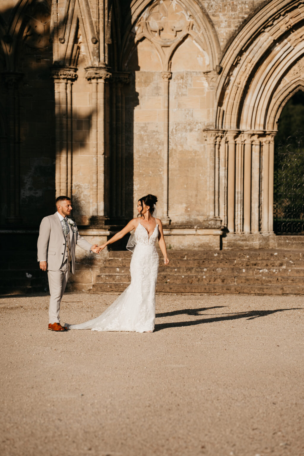 Bride and groom outside historical archway.