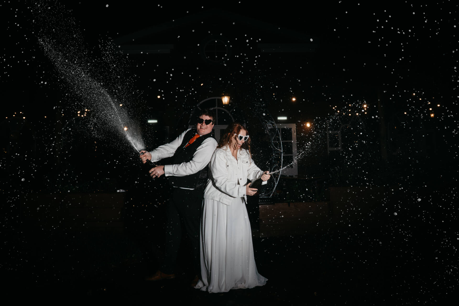 A man and woman in formal attire with water spouting out of them, captured by a Derby wedding photographer at the unique wedding venue, The Folly.